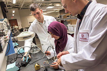 Three Engineering Medicine students working on electrical equipment