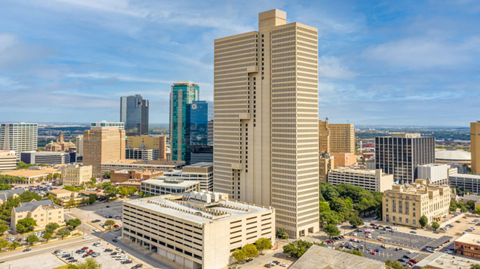 Exterior view of the Burnett Plaza high-rise with the downtown Fort Worth skyline behind it