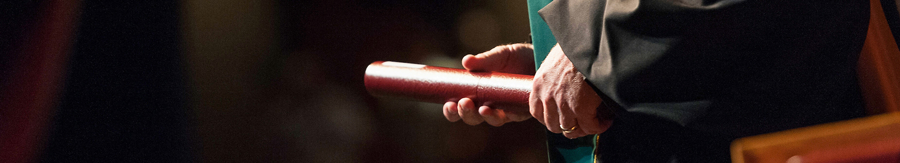 Hands holding diploma at graduation