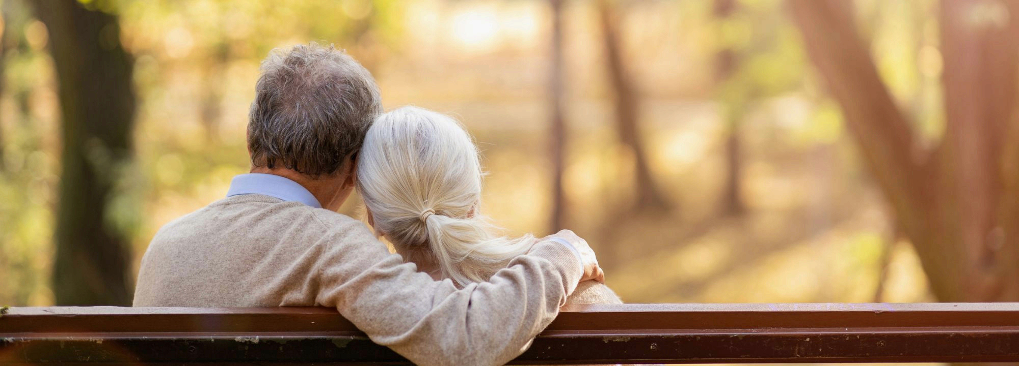 Couple sitting on a bench facing away from the camera