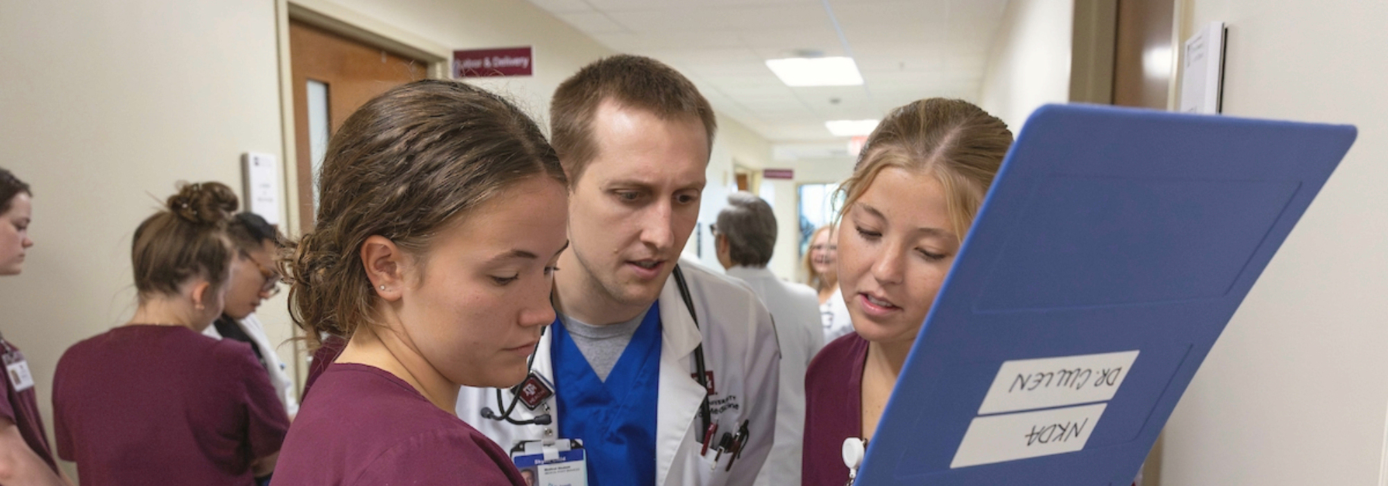Medical staff reviewing documents in hospital hallway