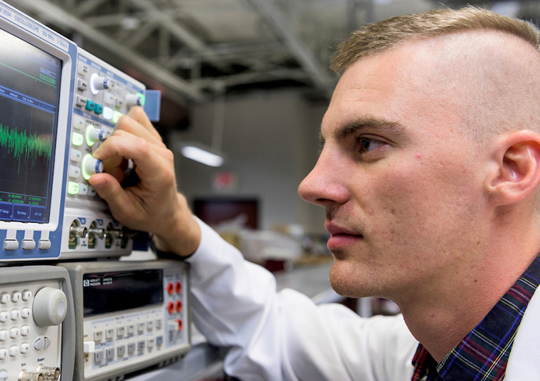 Engineering medicine student adjusting the dial on an instrument