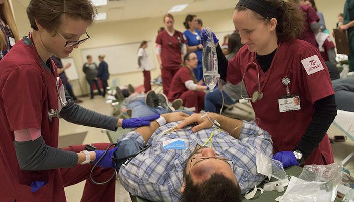 Nursing and medical students care together for a disaster victim on a stretcher