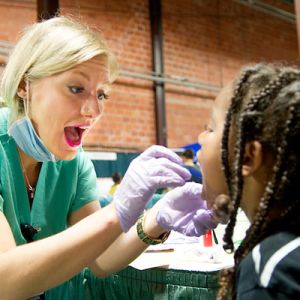 Dental hygienist examining a child patient