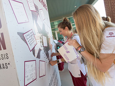 students writing messages on the opioid wall