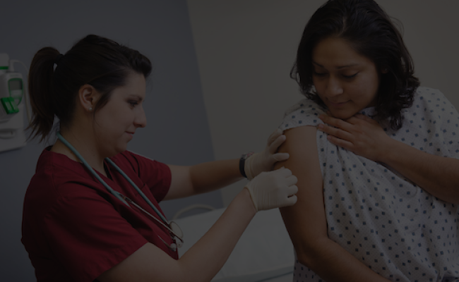 Nursing student giving a flu shot to a hispanic teen